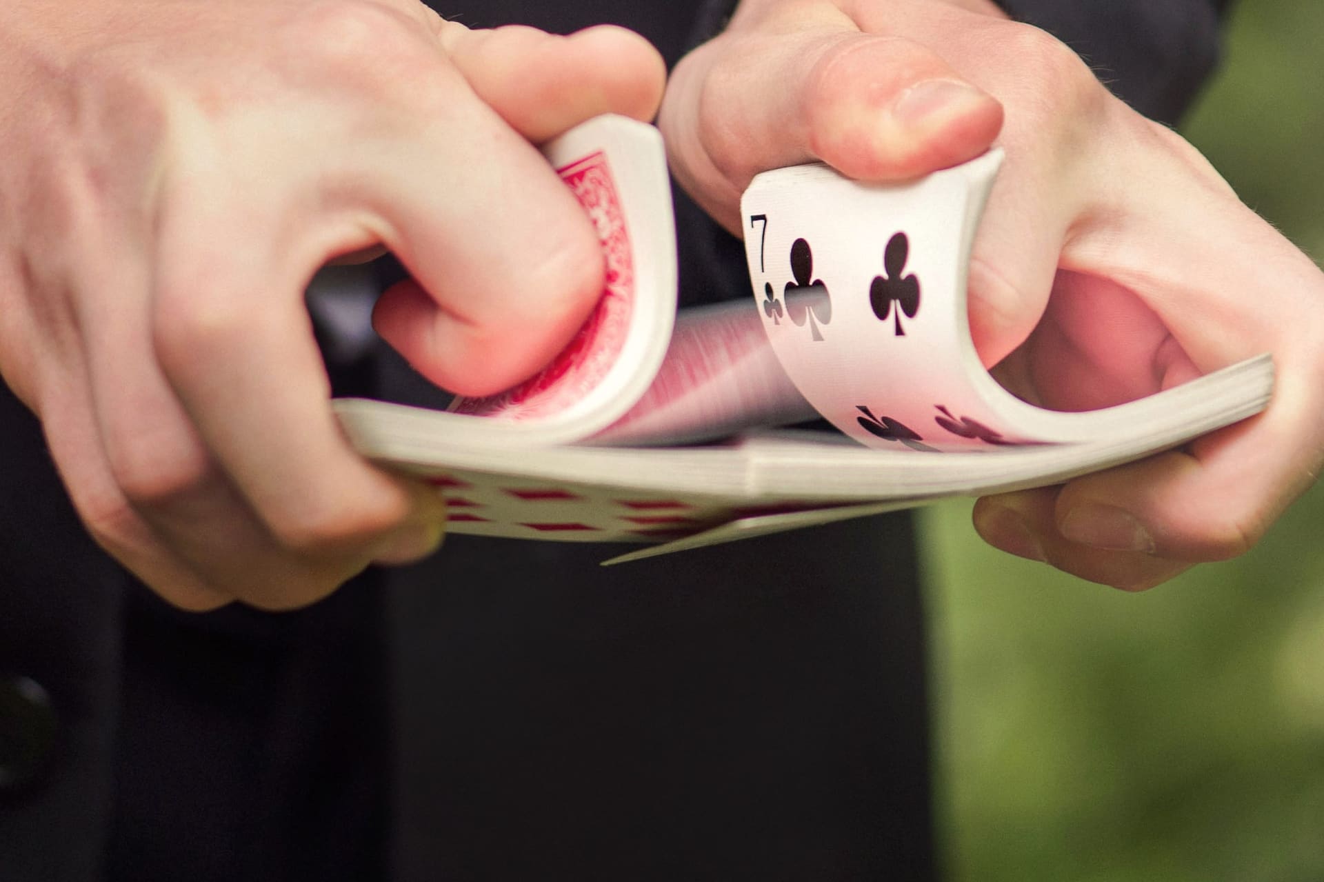 Close-up of a deck of playing cards being riffle shuffled in two hands